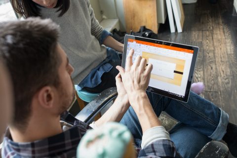 Male looking at tablet in family room.